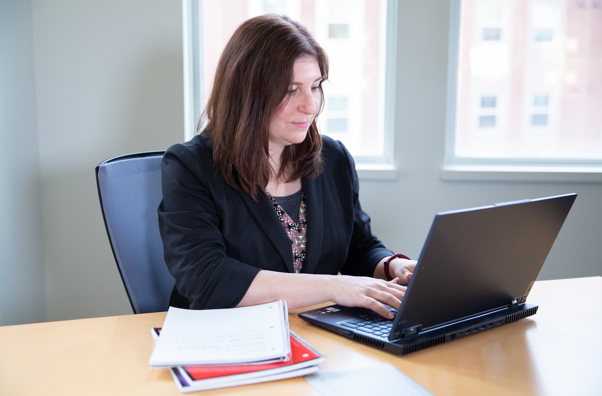 A student works on their laptop at a desk.