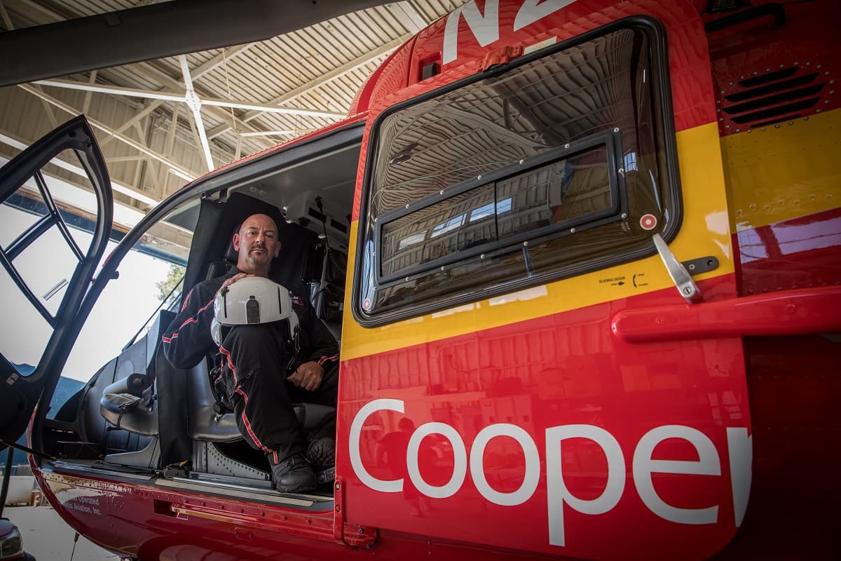 a man sitting in an emergency response helicopter looks at the camera