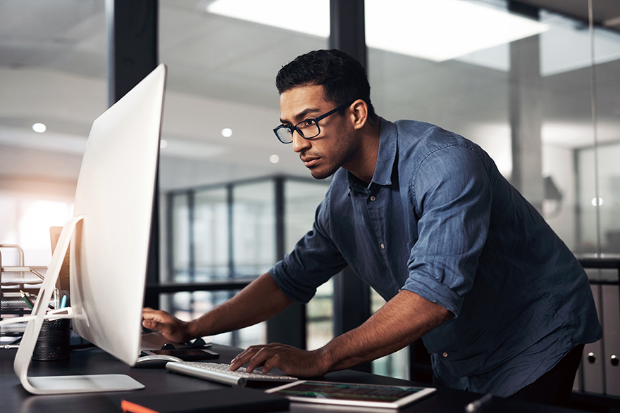 An individual working on a desktop computer.