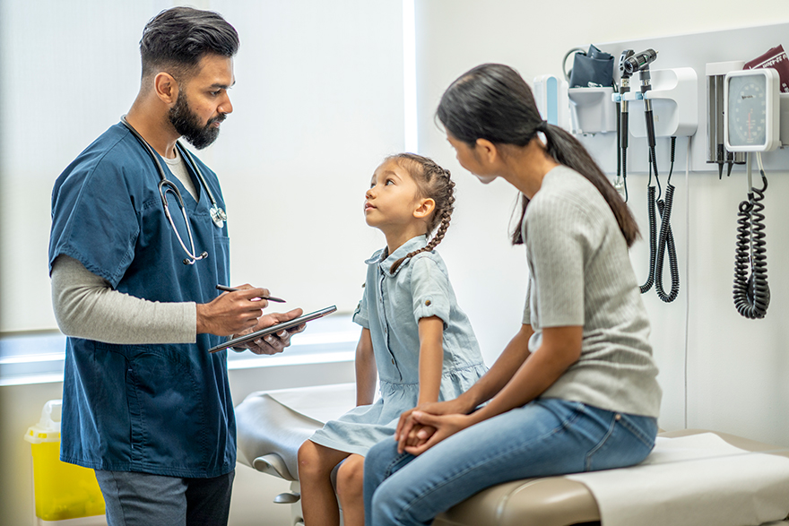 A healthcare professional speaks with patients in a medical setting.