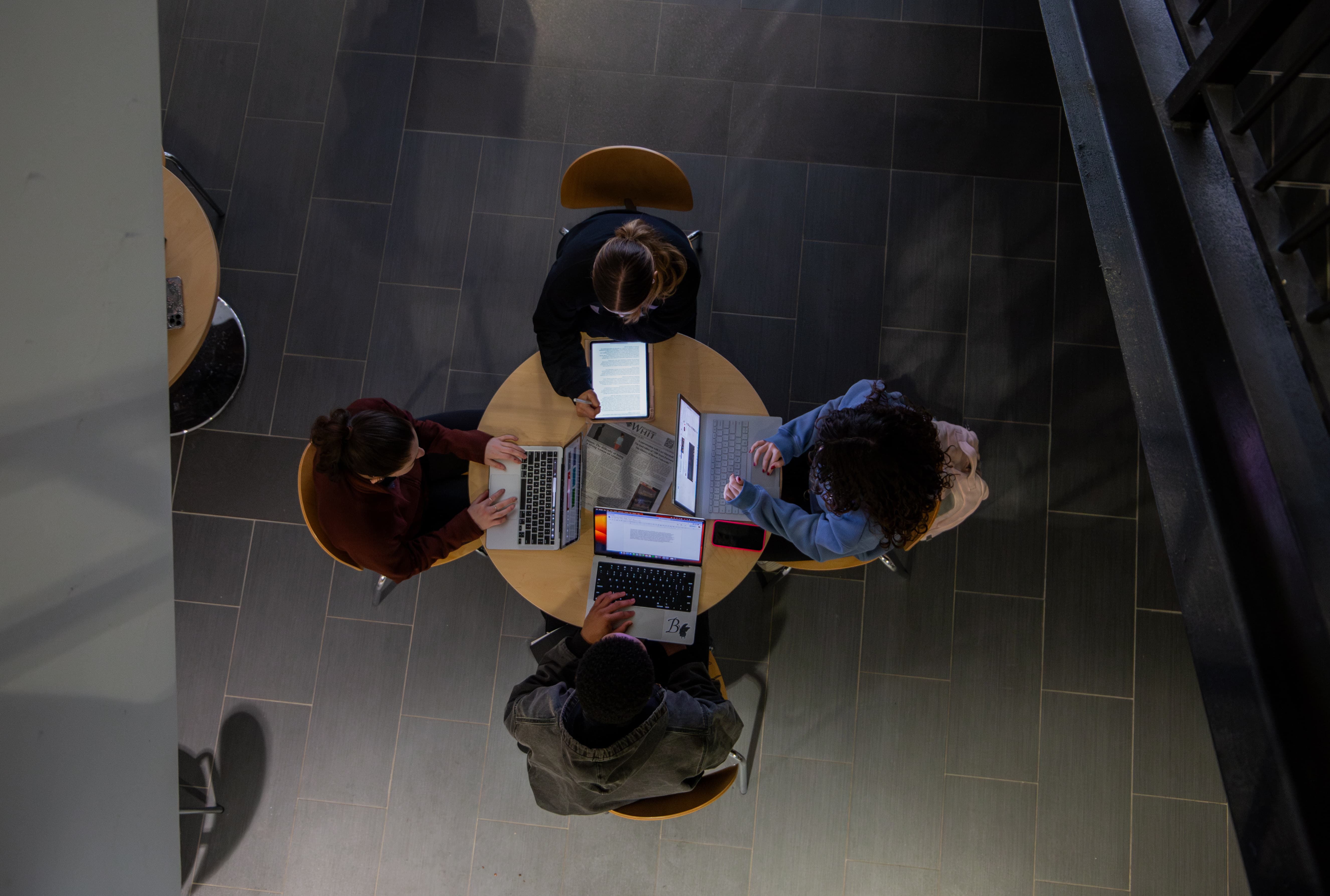 A group of students working on their laptops at a table.
