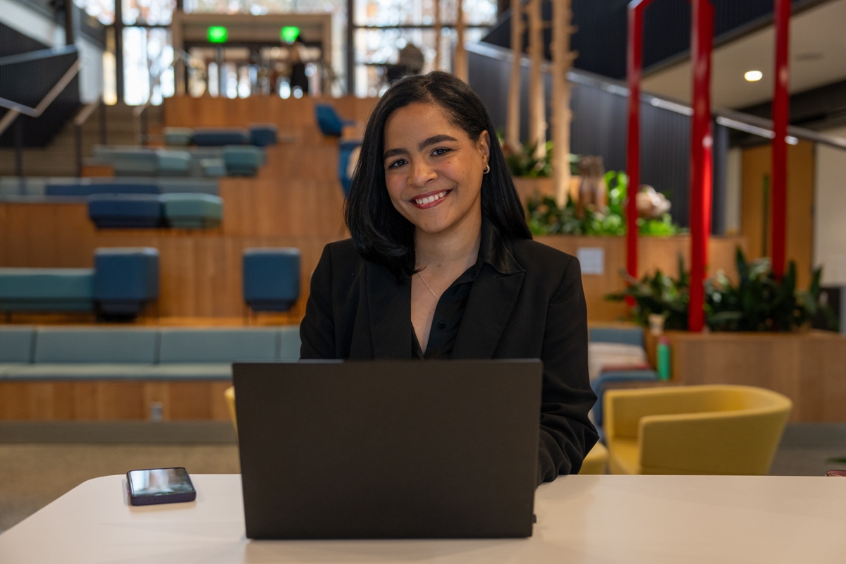 Flerida V. smiles while working on her laptop.