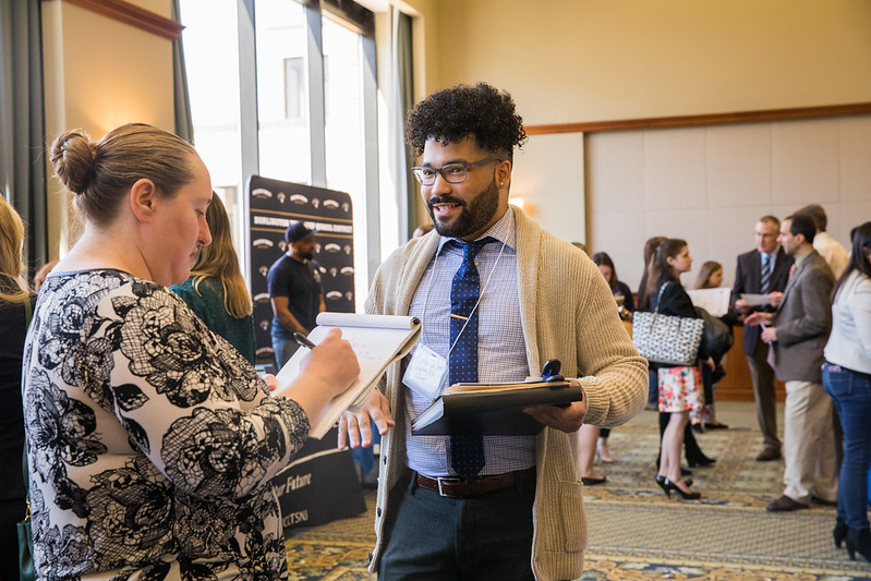 a student at a career fair speaking with a representative