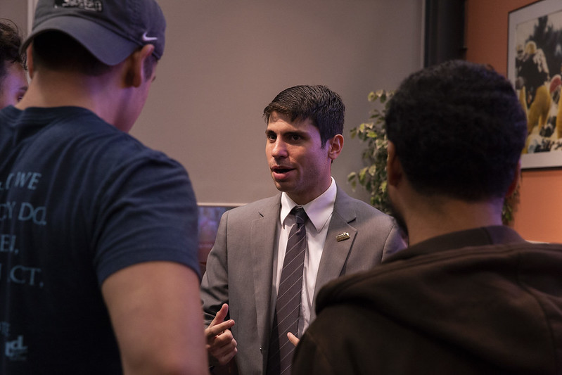 two students speaking with a counselor