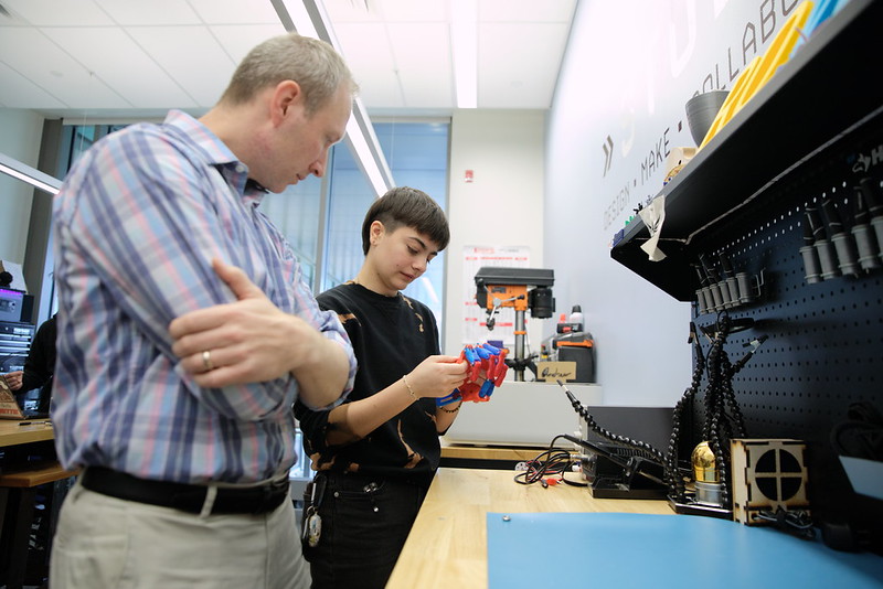 student in a lab working with a prosthetic hand